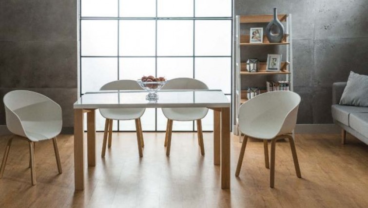 Białe krzesła na drewnianych nogach i stół z prostokątnym blatem o połyskującej powierzchni