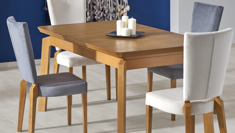Rozkładany stół z blatem w okleinie naturalnej i tapicerowane krzesła na bukowych nogach