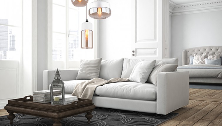 Dwukolorowe lampy wiszące ze szklanymi kloszami oraz komfortowa sofa salonowa