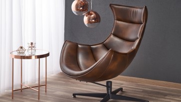 Obrotowy fotel ze skóry naturalnej oraz miedziany stolik kawowy z okrągłym blatem