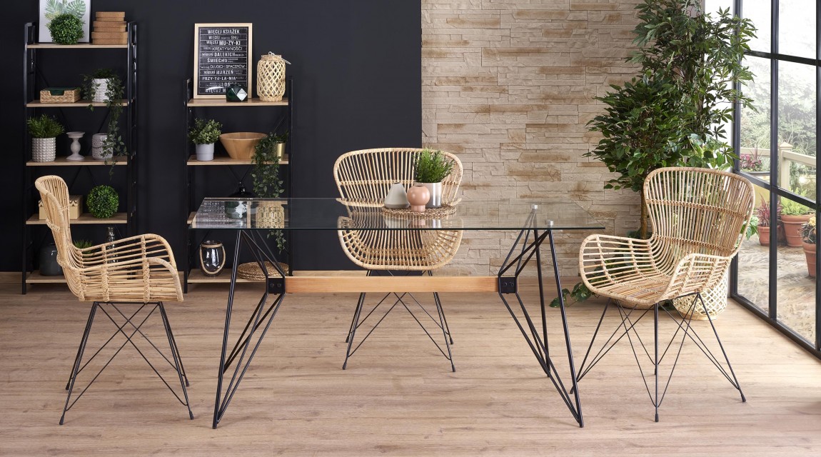 Stół ze szklanym blatem na designerskiej podstawie oraz rattanowe krzesła