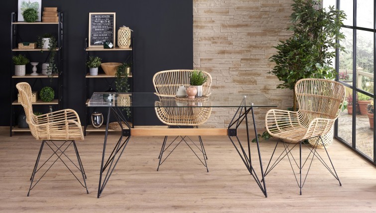 Stół ze szklanym blatem na designerskiej podstawie oraz rattanowe krzesła