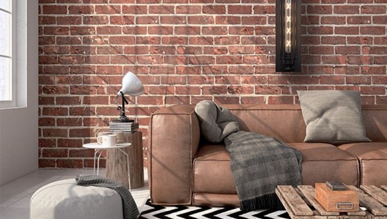 Industrialny kinkiet ścienny oraz niezwykle stylowa sofa skórzana z miękkimi poduchami