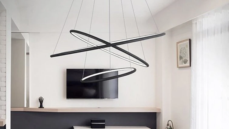 Szklany stolik kawowy na metalowej podstawie oraz designerska lampa wisząca