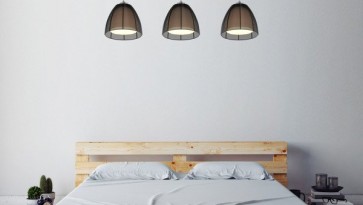 Potrójna lampa z metalowymi kloszami i dwuosobowe łóżko w naturalnym odcieniu drewna