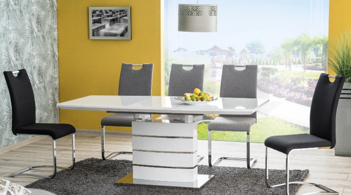 Biały stół ze szklanym blatem z szarymi i czarnymi krzesłami w przeszklonej jadalni