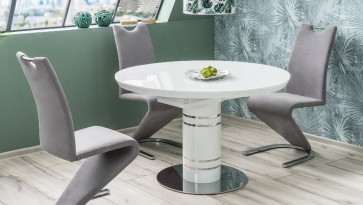 Okrągły stół do jadalni z krzesłami na płozach w niewielkiej jadalni na poddaszu