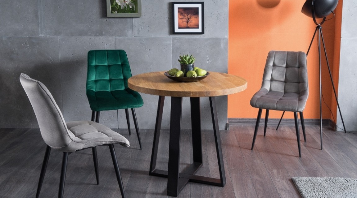 Okrągły stół w stylu industrialnym z tapicerowanymi krzesłami w jadalni połączonej z salonem