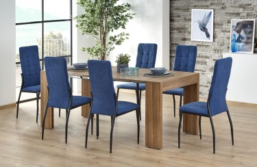Stół w kolorze drewna z rozkładanym blatem i niebieskie krzesła pikowane na metalowych nogach