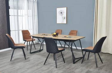 Rozkładany stół z drewnopodobnym blatem i tapicerowane krzesła na czarnych metalowych nogach