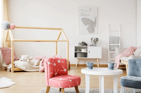 Pokój dziecięcy z kolorowymi fotelikami i okrągłym stolikiem w kolorze białym