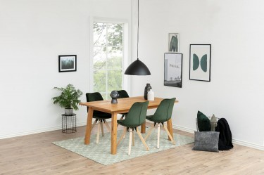 Drewniany stół czteroosobowy z krzesłami w stylu skandynawskim na zielonym dywanie