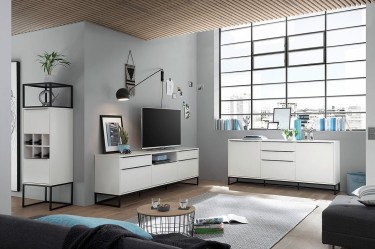 Białe meble matowe na płozach w stylu loft w dużym salonie z szarymi ścianami