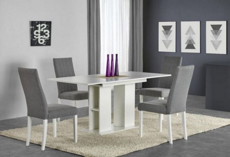 Zestaw mebli z rozkładanym stołem i tapicerowanymi krzesłami na kremowym dywanie w domowej jadalni
