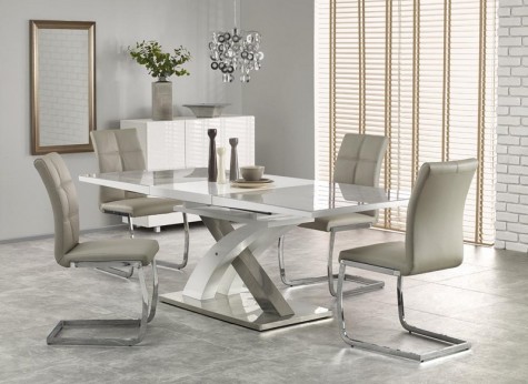 Biało - szary stół ze szklanym blatem na ozdobnej nodze w kształcie litery X i krzesła na płozach bez podłokietników
