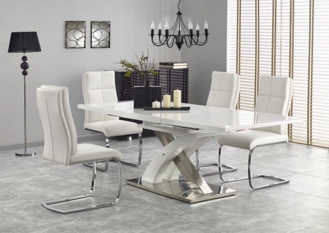 Rozkładany stół w wysokim połysku na designerskiej podstawie w towarzystwie wygodnych krzeseł z pikowanej ekoskóry