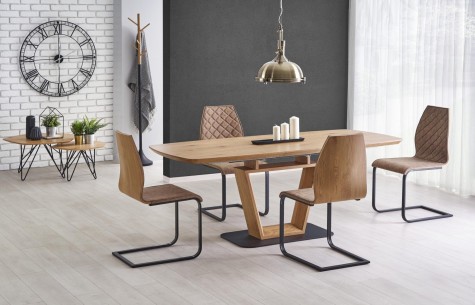 Rozkładany stół w nowoczesnej jadalni z krzesłami na metalowych płozach w towarzystwie białych i szarych ścian