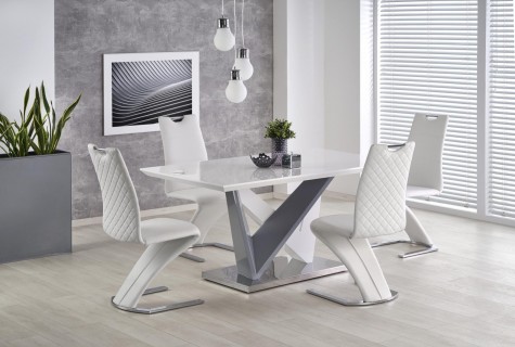 Biały stół z lakierowanym blatem w towarzystwie skórzanych krzeseł w nowoczesnej jadalni z dużym obrazem i żaluzjami