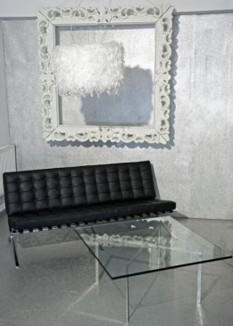 Pikowana sofa 3-osobowa z czarnej skóry naturalnej w salonie ze strukturą dekoracyjną na ścianie
