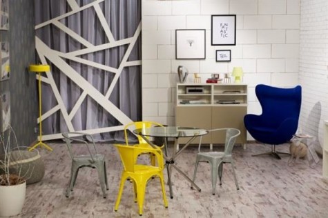 Nowoczesna aranżacja salonu z metalowymi krzesłami w stylu loftowym i tapicerowanym fotelem wypoczynkowym