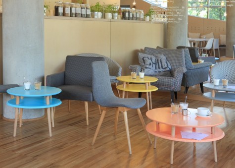 Kolorowe stoliki kawowe w stylu skandynawskim w nowoczesnym wnętrzu kawiarnianym