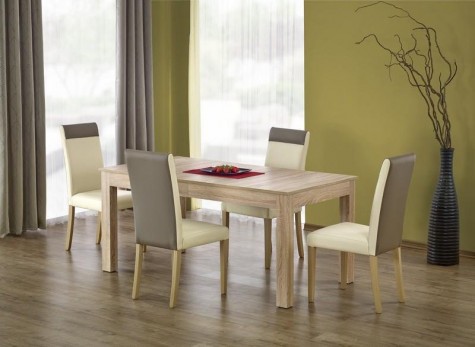 Zestaw mebli w postaci rozkładanego stołu i skórzanych krzeseł w jadalni z drewnianą podłogą i zielonymi ścianami