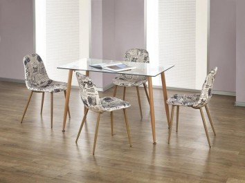 Nierozkładany stół ze szklanym blatem i tapicerowane krzesła z motywem na siedzisku i oparciu