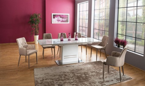 Rozkładany stół z blatem w dekorze marmur i krzesła tapicerowane beżową tkaniną