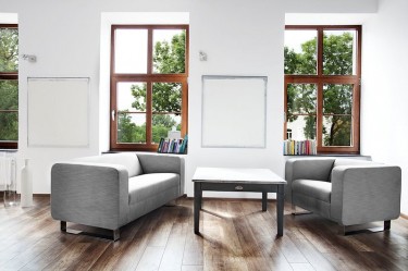 Tapicerowany fotel oraz dwuosobowa sofa w kolorze szarym na metalowych płozach
