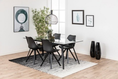Szklany stół na 4 nogach z metalu z czarnymi krzesłami w otwartej jadalni z wysokim oknem 