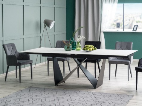 Designerski stół na metalowej podstawie z pikowanymi krzesłami w jadalni z zielonymi ścianami