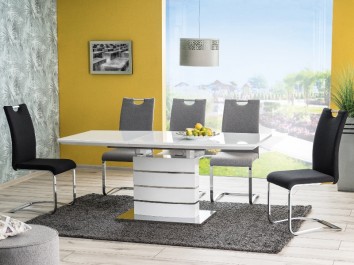 Biały stół ze szklanym blatem z szarymi i czarnymi krzesłami w przeszklonej jadalni